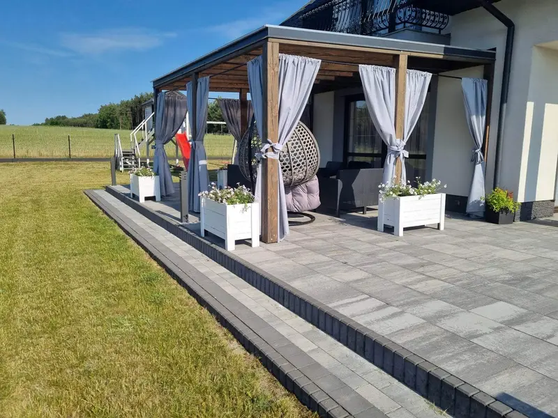 Drewniane zadaszenie tarasu z pergolą — realizacja LANDREW